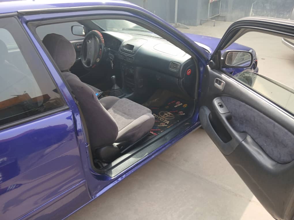 Intérieur de la Toyota Etio Compact : tableau de bord net, volant en bon état, sièges propres et habitacle entretenu avec écran central visible.